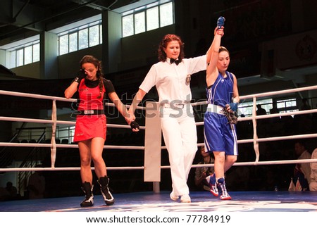 NOVOSIBIRSK - MAY 20: Russian Championship in women's boxing. Referee declares the winner semi-final battle between Panyan Gayane(red) and Isaeva Zoya(blue) on May 20, 2011, Novosibirsk Russia