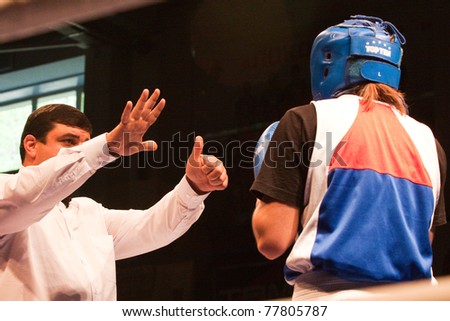 NOVOSIBIRSK - MAY 20: Russian Championship in women's boxing. The semi-final battle.  referee believes knockdown for Sablina Yuliya(blue) on May 20, 2011, Novosibirsk Russia