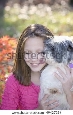 Pretty young girl getting kisses from her adorable Shih-zu/Jack Russell terrier mix puppy