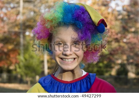 Cute girl dressed up in her halloween clown costume grinning from ear to ear