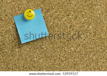 Blue paper with expressive thumb tack on bulletin board