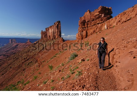 Woman hiking the Utah desert near the Castleton Tower, the Rectory and the Priest