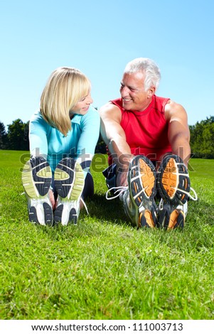 Happy senior fitness couple in the park.