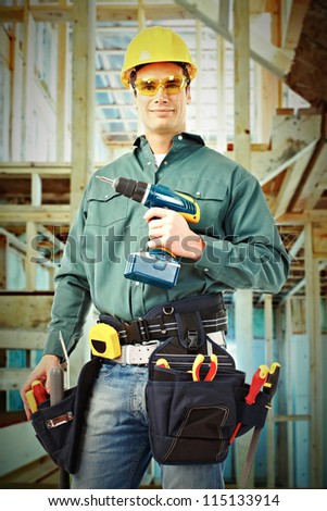 Young handsome Worker man with a drill. Construction.