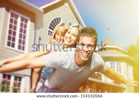 Happy smiling family with child over  house background