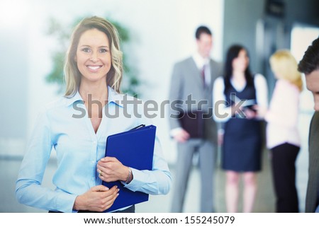 Bussinesswoman with black tablet over team background