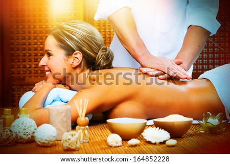 Beautiful woman having relaxing in spa massage salon.