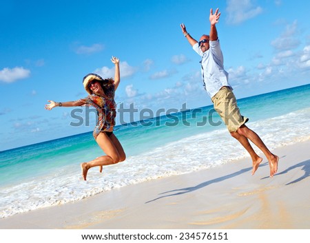 Happy couple jumping on the beach. Crazy vacation