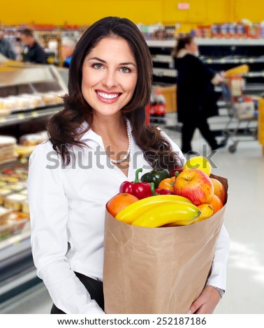 Young beautiful woman with a grocery bag in supermarket