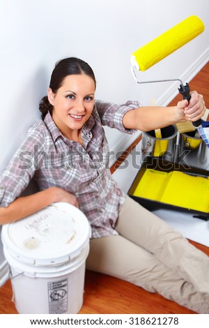 Beautiful woman with painting roller. House renovation.