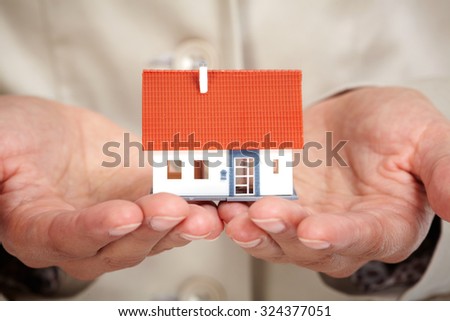 Hands with little house. Real estate and construction background.