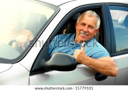 Smiling happy elderly man  in the new car