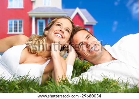 Young love couple smiling dreaming about a new home.  Real estate concept