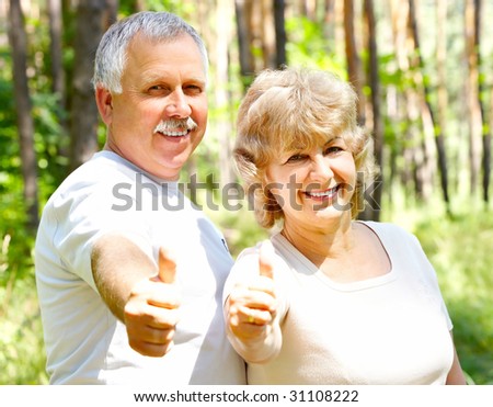 Smiling happy  elderly couple in summer forest