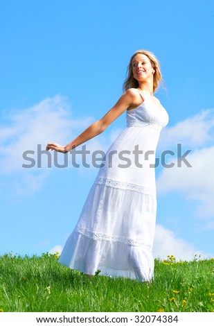 Beautiful young happy woman under blue sky.