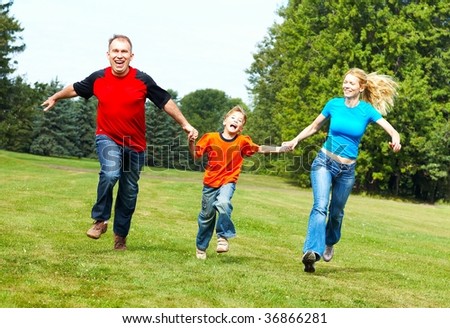 Happy family. Father, mother and sons running  in the park