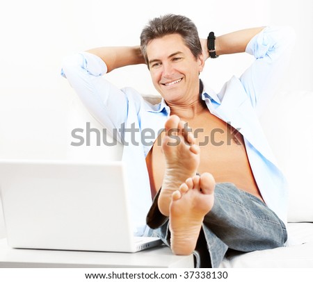 Happy smiling man with laptop at home