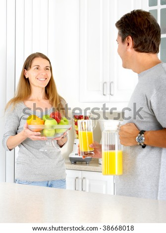 Adult smiling woman and man  in the kitchen