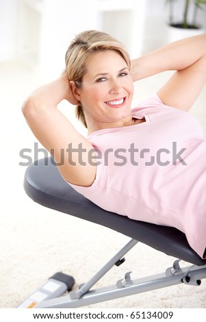 Gym & Fitness. Smiling elderly woman working out.