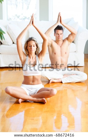 Young man and woman woman doing yoga in the sunny room