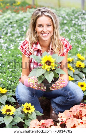 Young smiling woman florist working in the garden