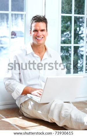 Young happy man with laptop at home