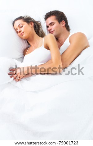 Young happy couple sleeping in bed. Love.