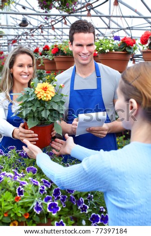 Young smiling seller florist working in flower shop.