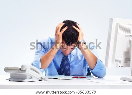 Busy businessman having headache at the office.
