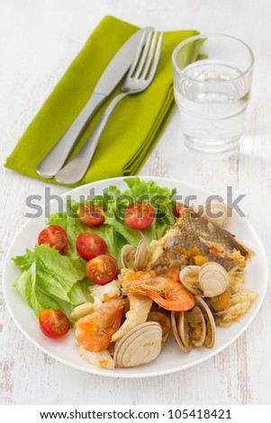 fish stew with salad on the white plate