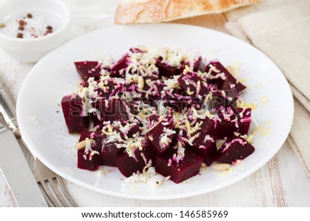 salad with beet, nuts and egg on white plate