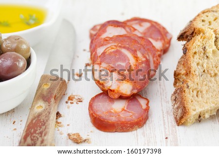 smoked sausages with olives, bread and oil