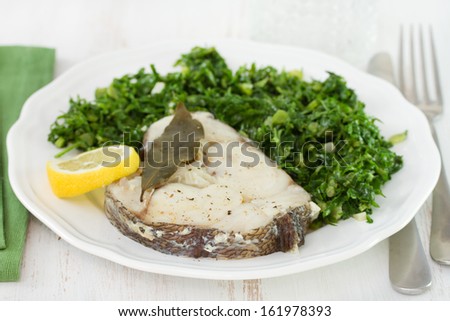 boiled fish with lemon and cabbage on plate