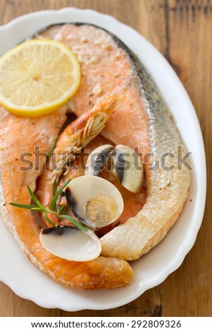fried salmon with seafood and lemon on dish