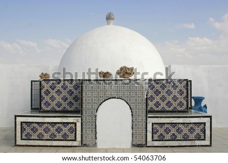 Decorative oriental, arab style cupola on top of the building in Tunisia with desert roses and vases on it