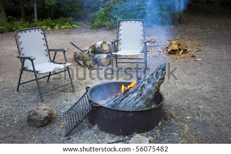 Two chairs sitting around the campfire in the woods