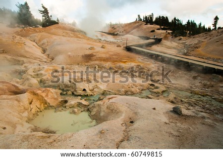 Mud pits and hot pools with boardwalks over the land in a volcanic area