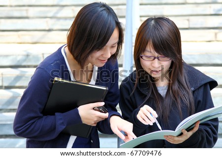 Two smart Chinese University students discussing on campus