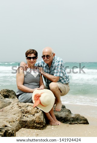 Happy elderly couple enjoying their retirement vacation near the sea