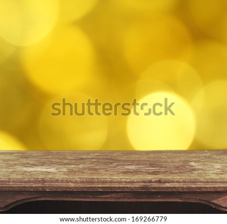 Vintage wooden table with yellow bokeh background