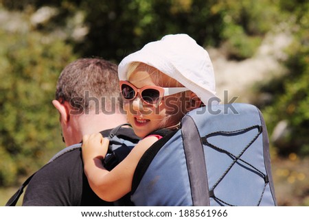 Father hiking with kid on backpack