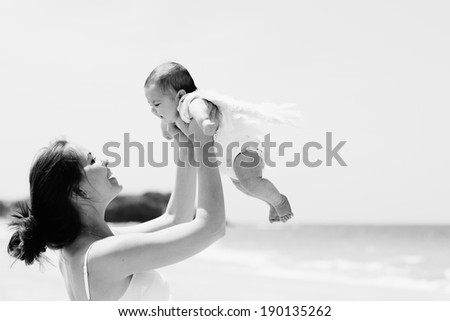 Portrait of happy loving mother and her baby at the beach