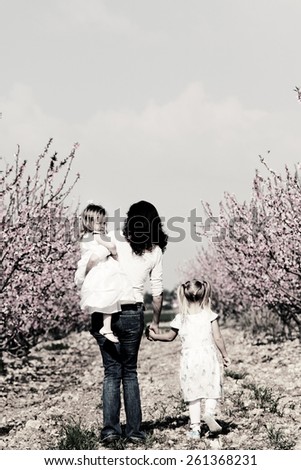 mother and daughters walking together in the park