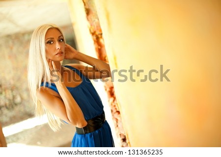 Beautiful sexy blonde girl posing in an old building collapsed