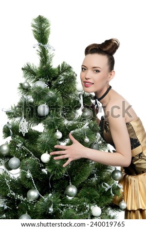Beautiful sexy brunette girl in a gold dress the Christmas tree on a white background isolated