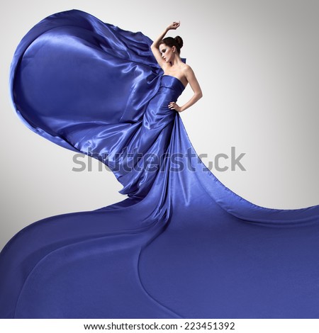 Young beauty woman in fluttering blue dress.