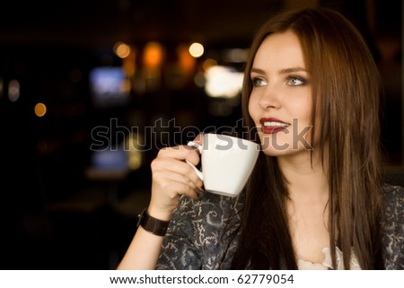 Beautiful young girl sipping coffee