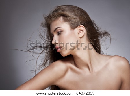 Beautiful woman with fluttering hair. On dark background.