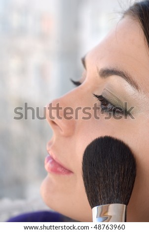 Beautiful young woman use makeup brush