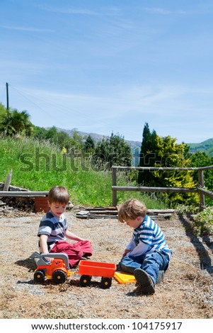 Two boy play outdoor with toys